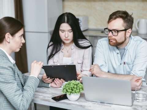 Newcomer entrepreneur reviewing business loan options in Canada with laptop and financial documents