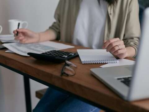 Business owner reviewing finances with a calculator and tax forms to understand tax-deductible business loans in Canada