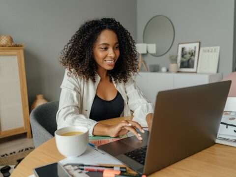 A laptop showing an online business loan application form with Canadian currency on the desk, representing Bizfund’s digital financing services.