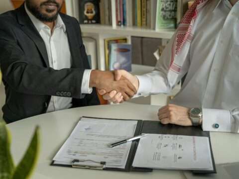 Two business professionals shaking hands after securing funding for their company.