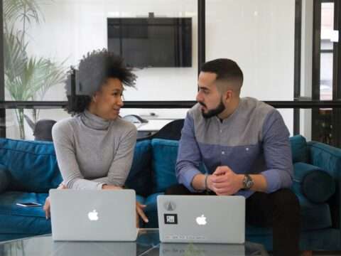 Canadian entrepreneur reviewing funding options on a laptop with charts and documents on a desk