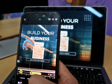 An individual scanning a QR code to learn how to start a business at an event.