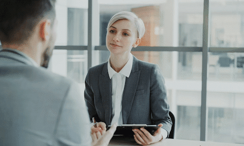 A woman interviewing an individual for a business position that has opened up
